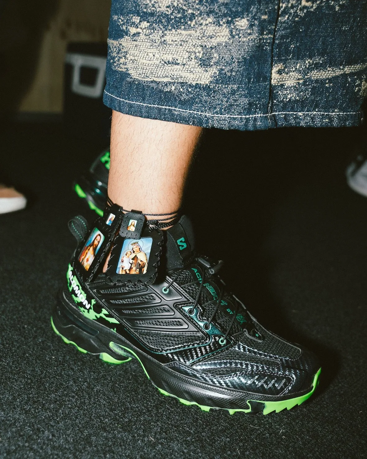 Detail of the Salomon ACS Nexxt's leather cage and religious icon heel tags