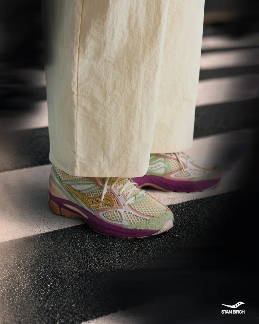 On-foot view of the Saucony x Stan Birch ProGrid Guide 7 worn with cream trousers on a crosswalk