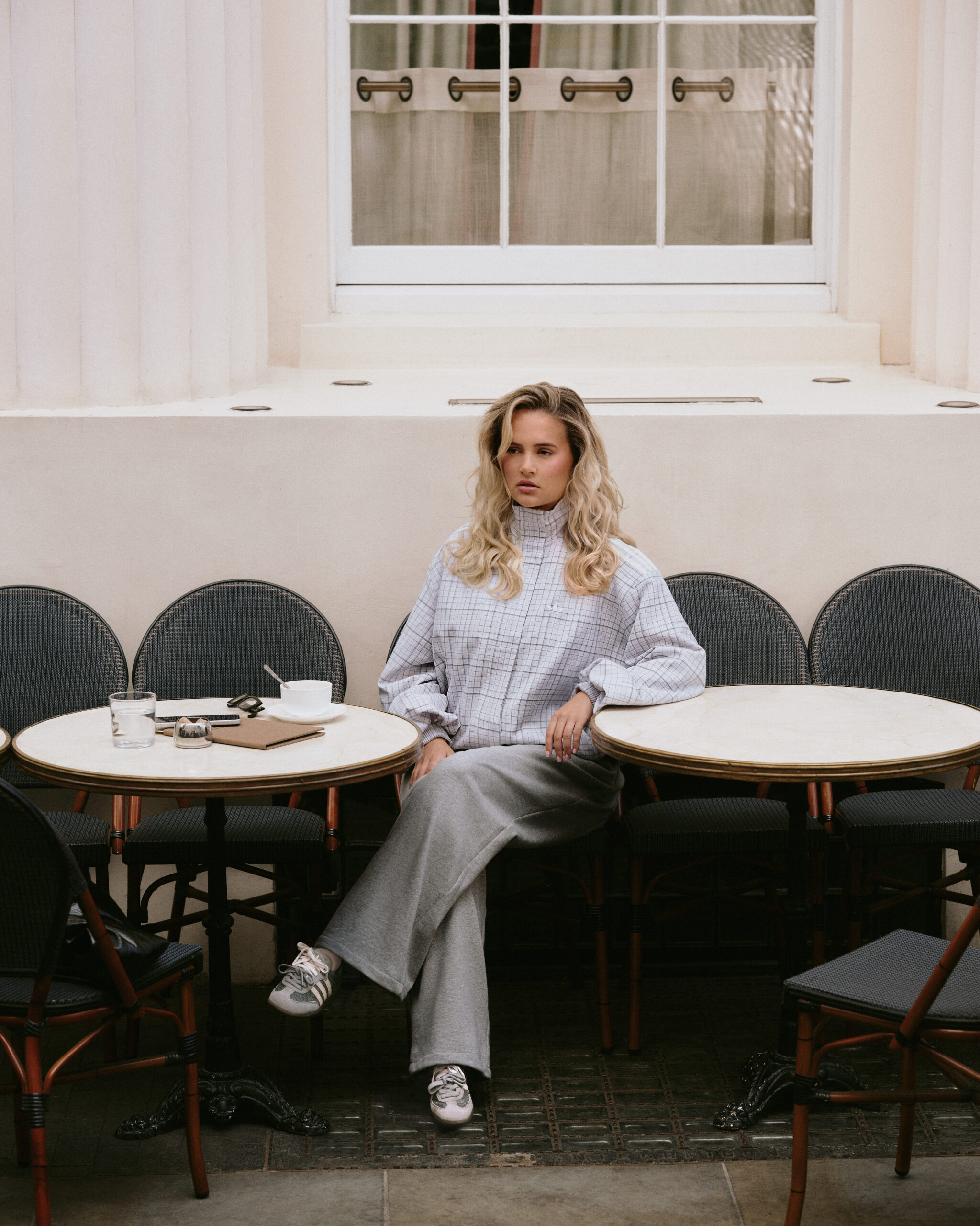 Molly-Mae Hague sat outside a caf&eacute; in the adidas Samba Slate
