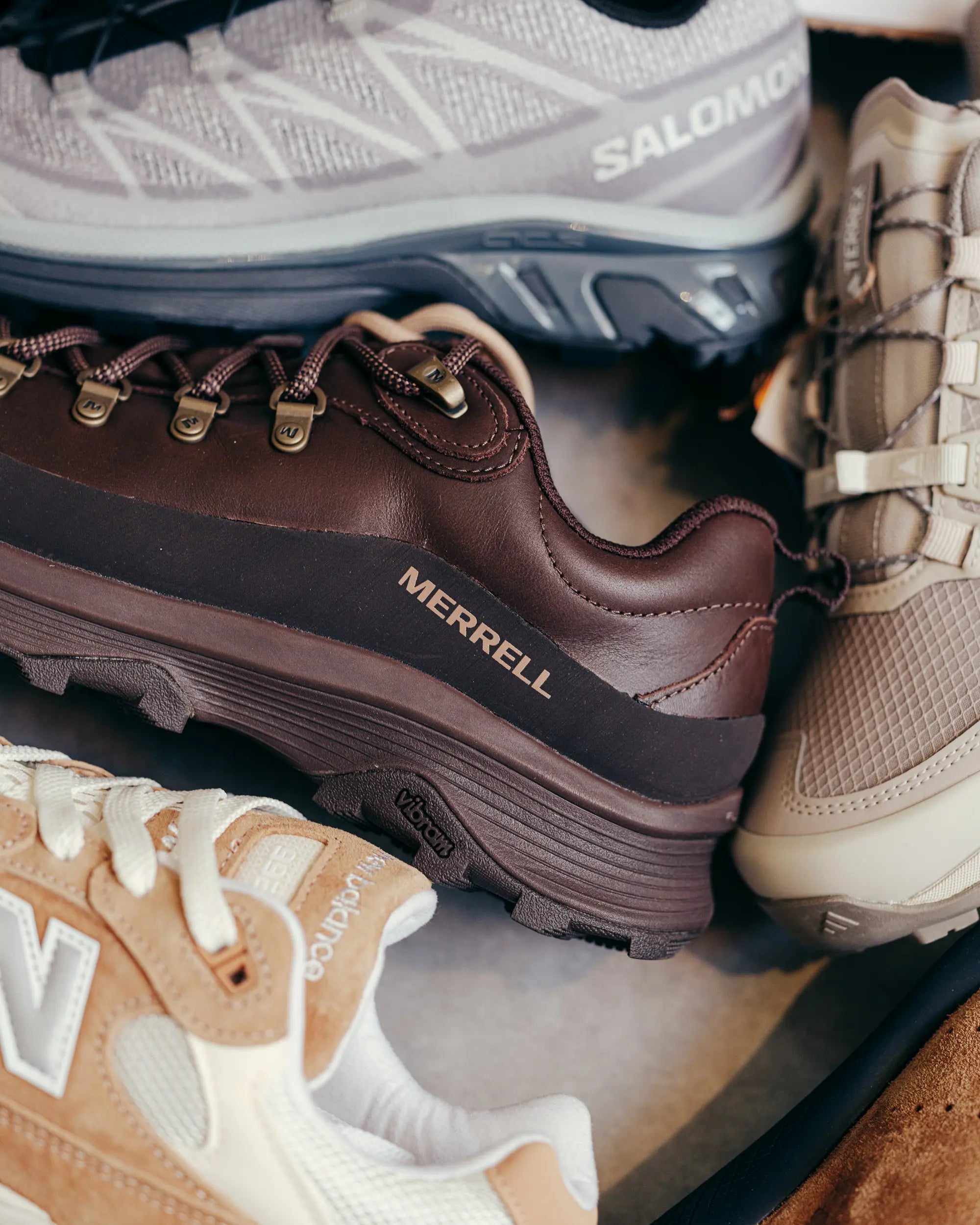 Nahaufnahme von vier Hiking-Sneakern aus braunem Leder, beigem Mesh, grauem Strick und Wildleder