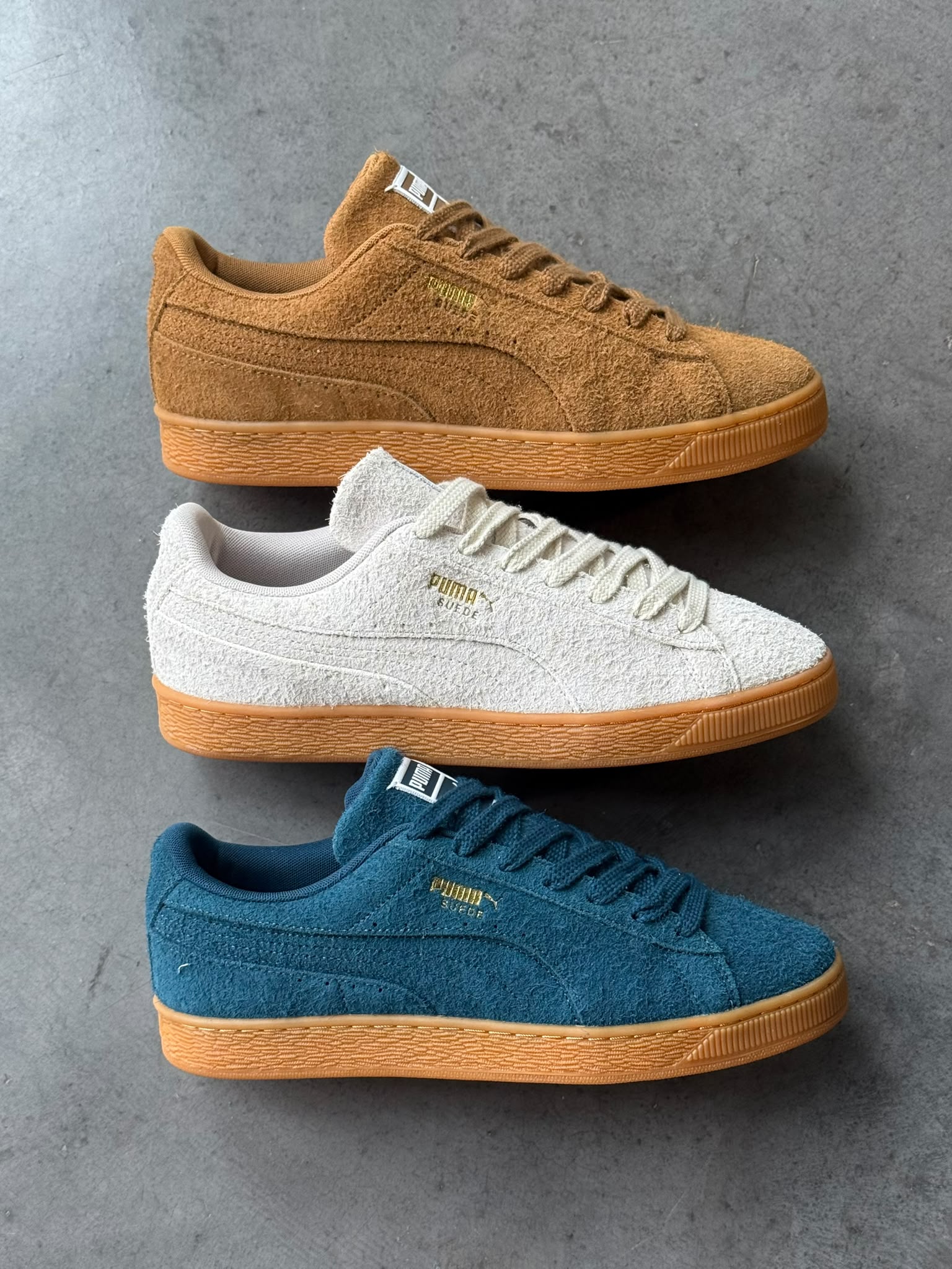 Side profiles of the PUMA Suede Forever in Kona Brown, Silver Fog and Midnight Petrol