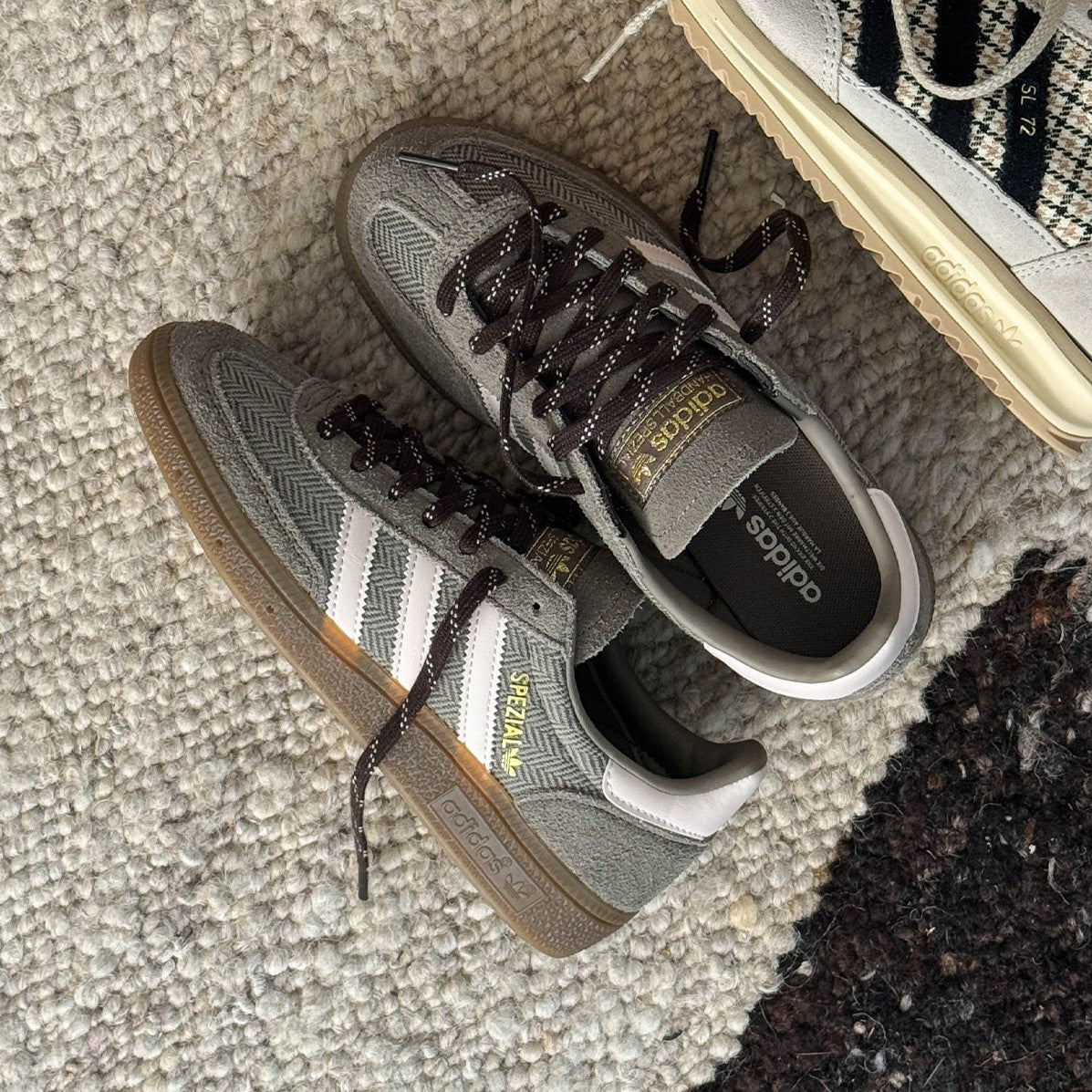 Graubraune Wildleder-Terrace-Sneaker mit weißen Streifen und Gum Sole auf einem Teppich