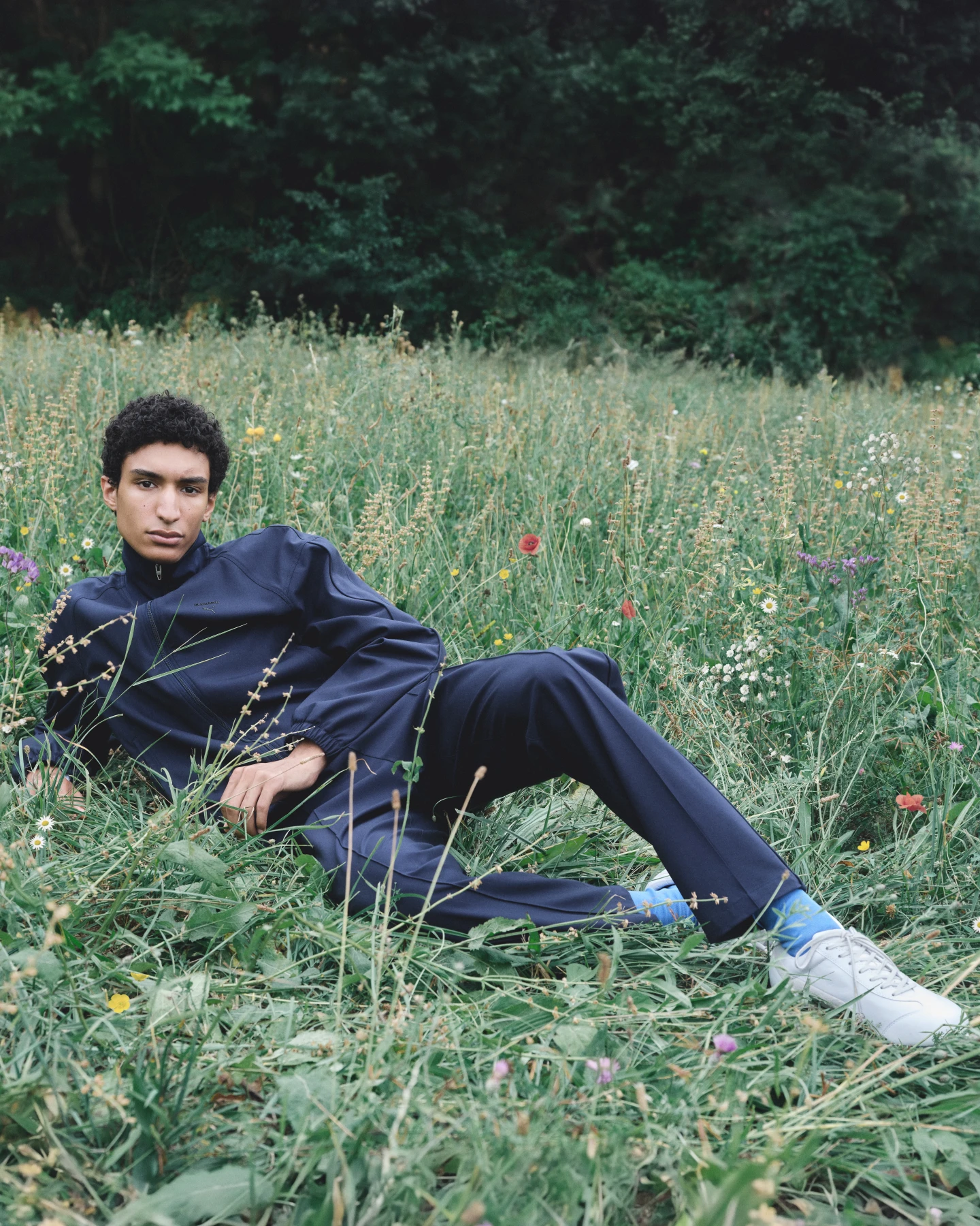 PUMA x JIL SANDER T7 tracksuit in Club Navy in a wildflower field