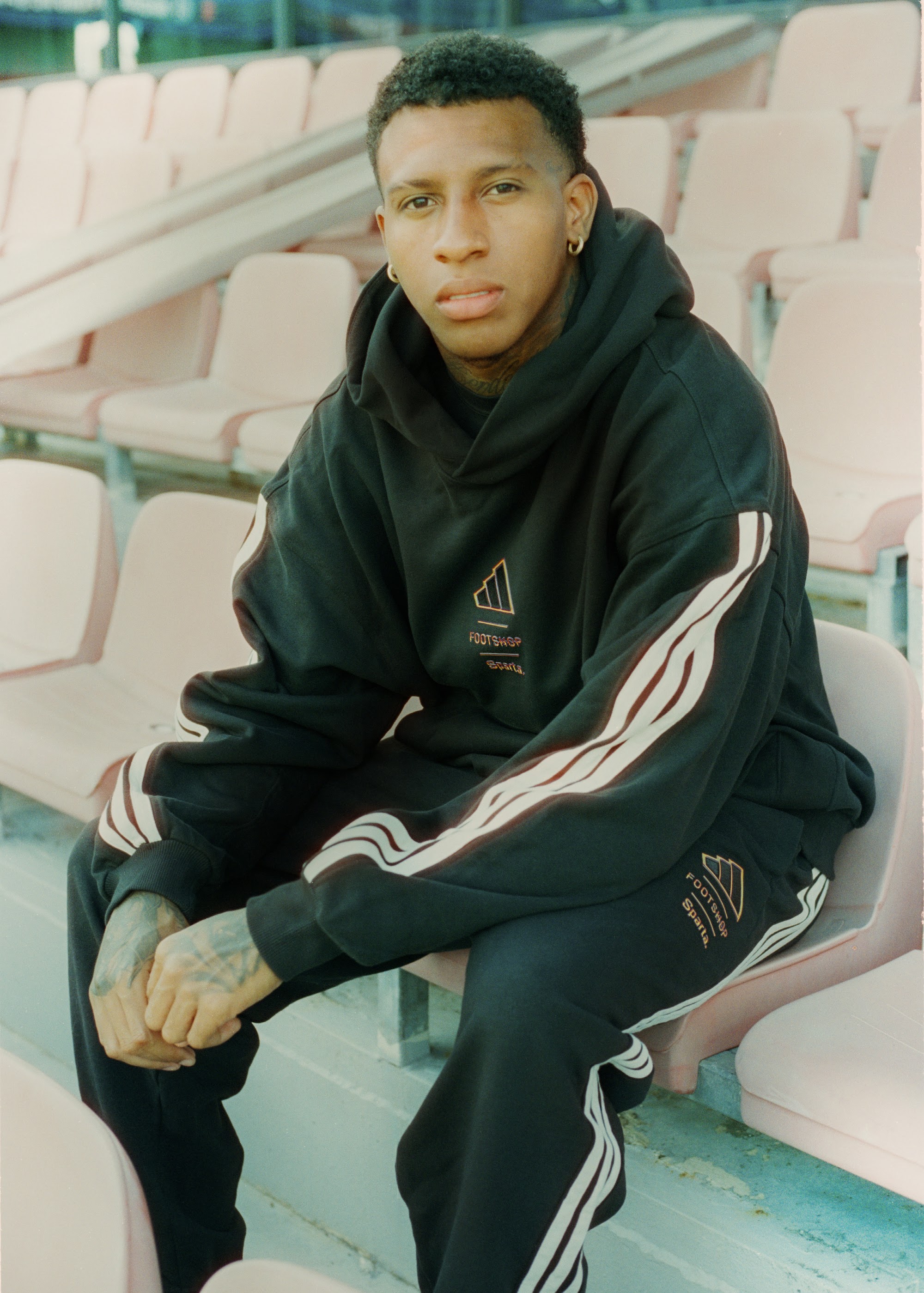 Zwarte hoodie uit de adidas x Footshop x Sparta-capsule op de tribune