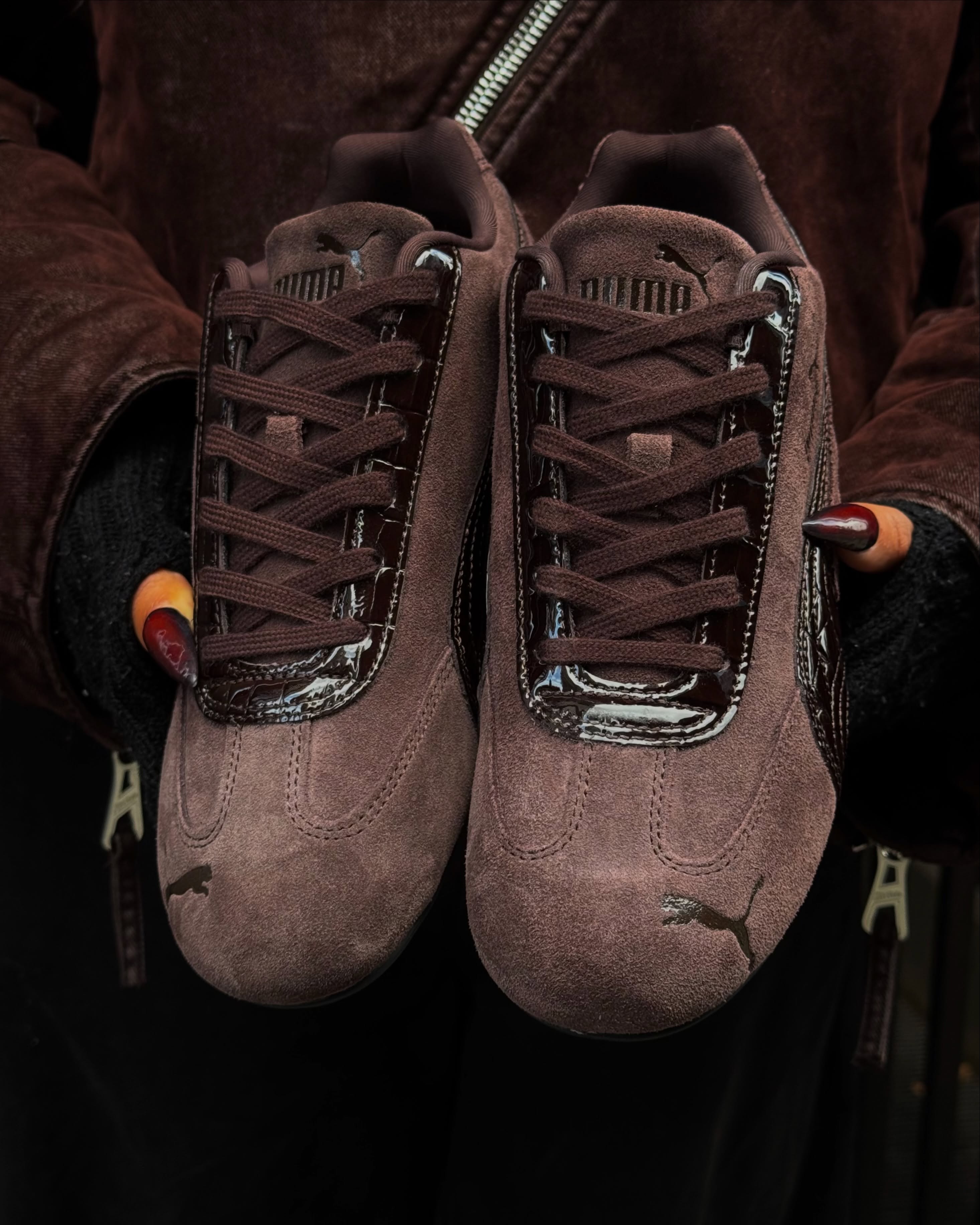 Pair of PUMA Speedcat Croco in Chocolate Fondue held up from above