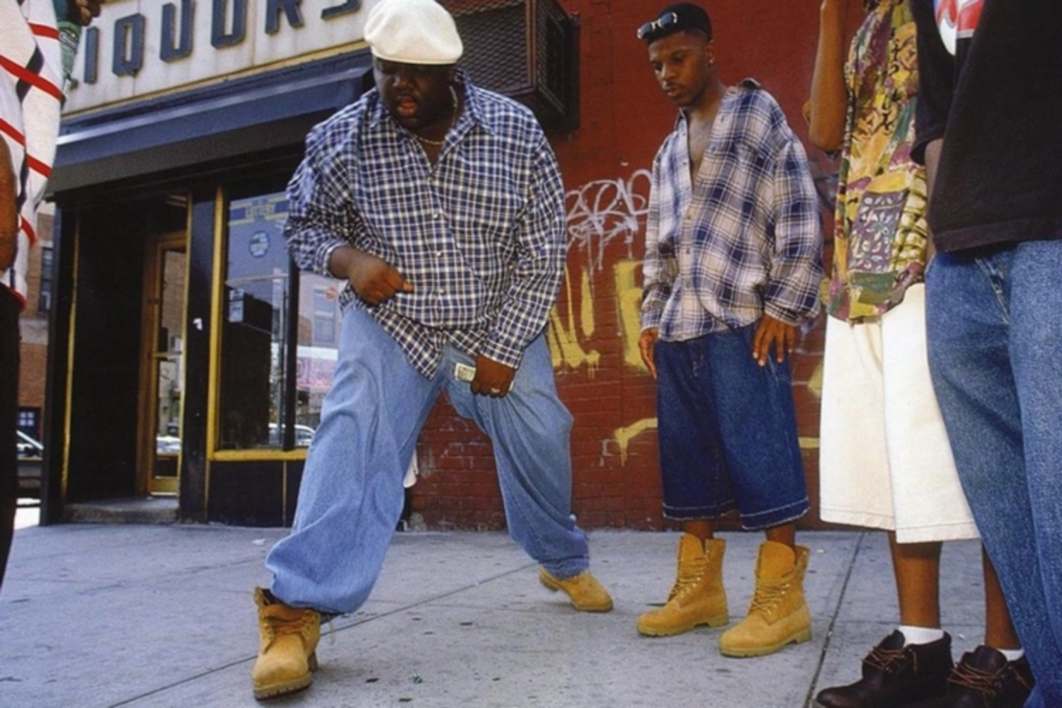 Group of young people wearing oversized clothing and classic yellow Timberland boots on a city street in the 1990s.